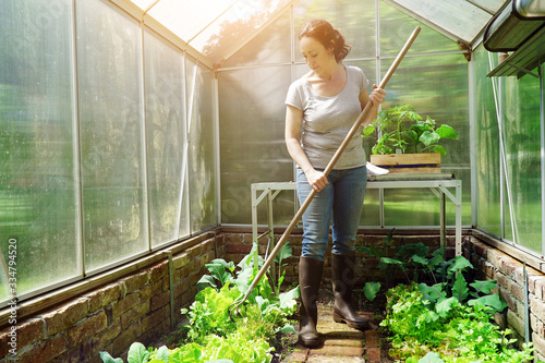 Photographie Woman in a greenhouse in the garden at gardening and plant care