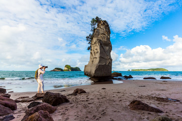 Sticker - Cathedral Cove. Woman taking pictures