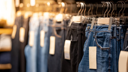 Wall Mural - Jeans or Denim pants (trousers) hanging on rack in clothes shop. Fashion product collection in clothing store for selling. Textile industry and business concept