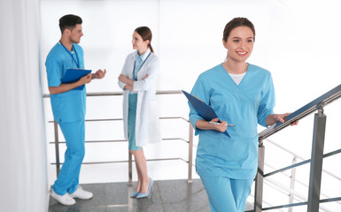 Poster - Female doctor going upstairs in modern clinic