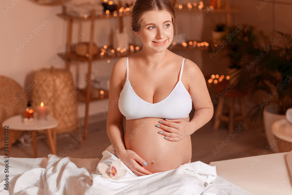 Young pregnant woman resting in spa salon