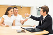 © xartproduction - real estate agent is selling an apartment to a young family. conclusion of a lease and purchase of a house, apartment. man shows housing