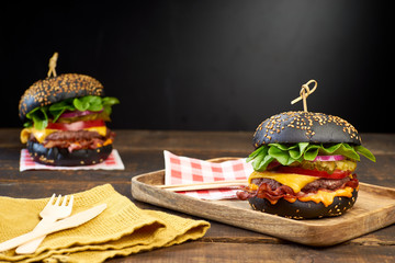 Wall Mural - Two juicy black hamburgers on dark wooden background