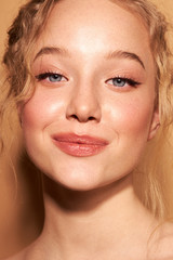 Portrait of young happy woman. Clean skin. Curly hair Blue eyes. Natural retouching.Arrows on the eyes 