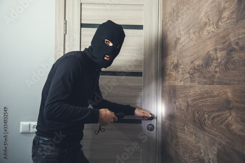 Cuadros en Lienzo burglar sneaking into the house with flashlight