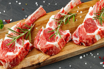 Racks of lamb ready for cooking on dark background, close up