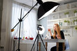 © artiemedvedev - Beauty blogger woman filming daily make-up routine tutorial on camera. Influencer blonde girl live streaming cosmetics product review in home studio with professional lighting equipment. Vlogger job.