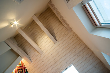 Wall Mural - Wooden ceiling in a contemporary mansard room with attic window ob decorative planks surface.