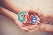 Adult and child hands holding Give word, kind, donate, charity and compassion concept