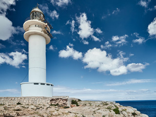 Lighthouse on the Formentera island, Spain, the blue sky with white clouds, without people, rocks, stones, sunny weather