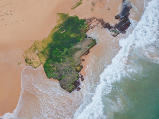Wall Mural - A big mossy rocks on the beach coastline.