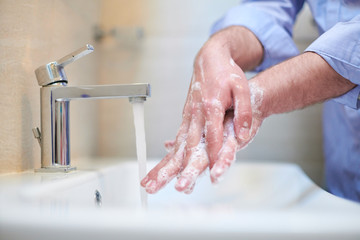  coronavirus male wahing hands in bathroom