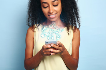 Wall Mural - Portrait of beautiful African-American woman with mobile phone on color background