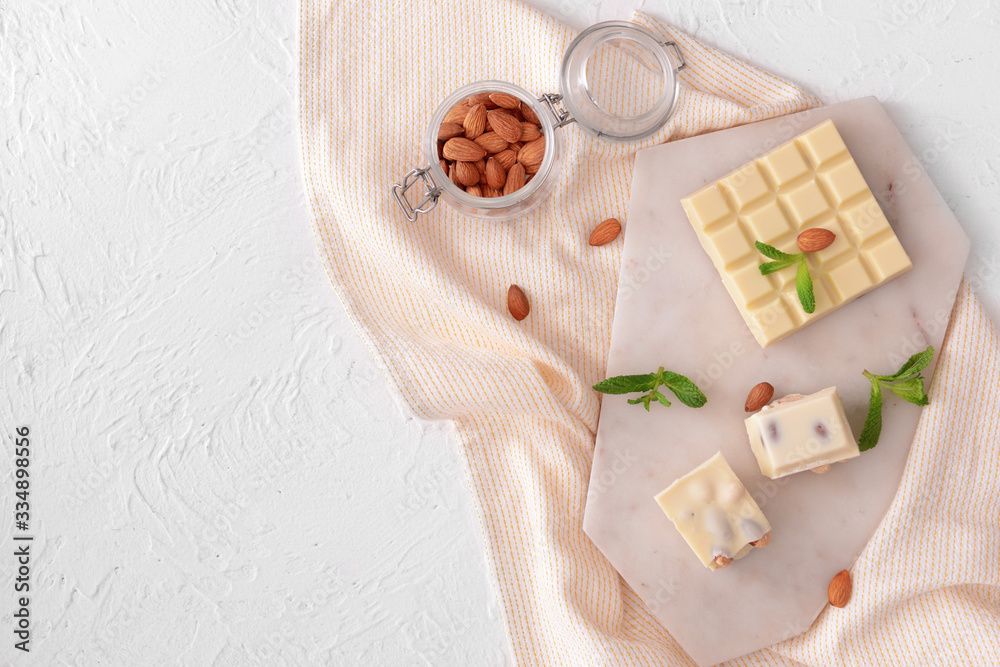 Sweet white chocolate with nuts and mint on table