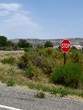 Portrait view, stop sign erected in the grassy part along the highway in Cody, Wyoming.