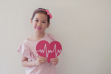 Wall Mural - Mixed race child holding big red heart with cardiogram,  children health care, life insurance business concept, world heart day, world health day