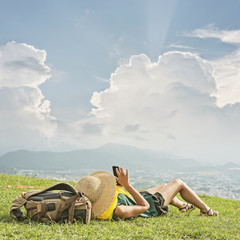 Wall Mural - woman lie on grassland and using cellphone