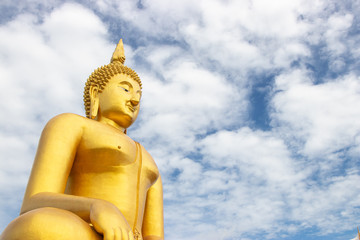 Wall Mural - The biggest sitting Buddha image in Thailand at Wat Muang Temple. The image, made of cement and painted in gold color.