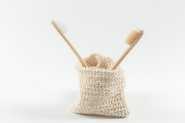 two natural wood toothbrushes in an ecological bag. zero waste. on white background.