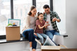 © Syda Productions - mortgage, family and real estate concept - happy mother, father and little daughter with house model and stuff in boxes moving to new home
