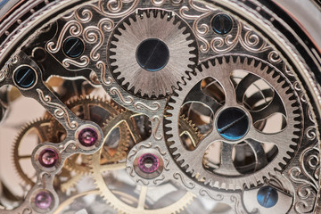 precise gears of a pocket watch, six rubies are seen