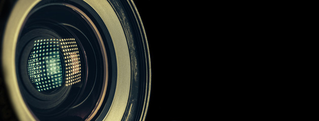 Poster - CLOSE UP Beautiful camera lens with light reflection on a black Background pattern for design..