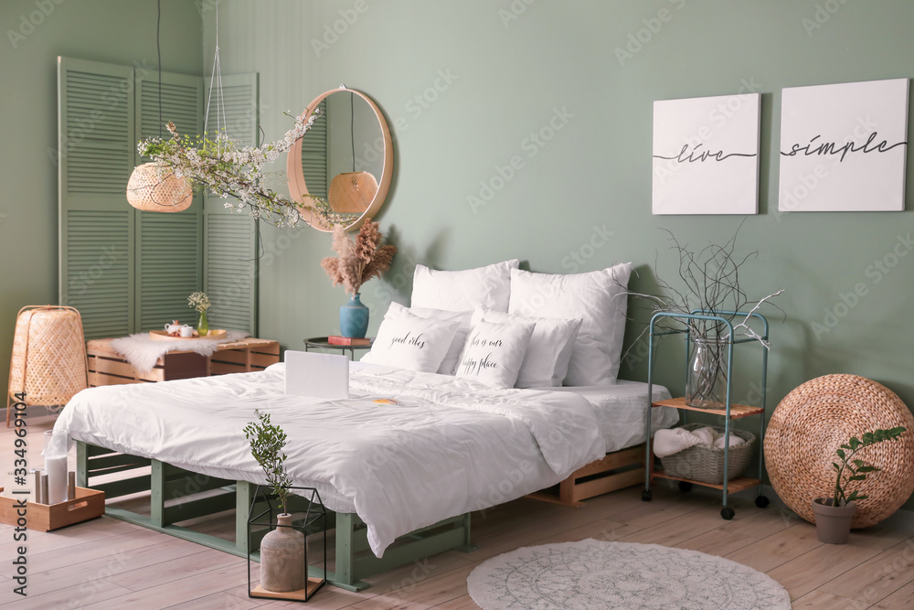 Interior of beautiful modern bedroom with spring flowers - obrazy, fototapety, plakaty 