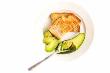 healthy breakfast on a white plate with toasted bread, avacado and fried eggs