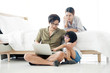© Pruksachat - Asian family using notebook in bedroom. Father works with a notebook. With a mother and child to support