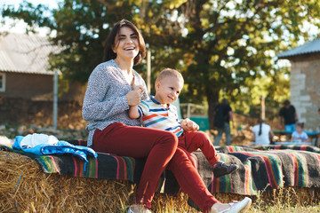 Poster - mother holding son's hands on haystack