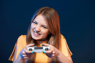 Wall Mural - Emotional girl playing video game with joystick