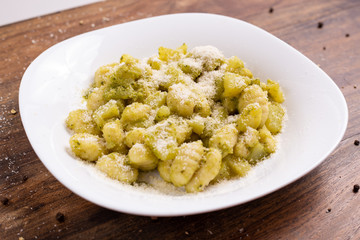 Wall Mural - Italian homemade gnocchi with basil sauce and potatoes. Traditional dish of Italian cuisine, vegetarian food.