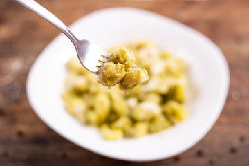 Wall Mural - Italian homemade gnocchi with basil sauce and potatoes. Traditional dish of Italian cuisine, vegetarian food.