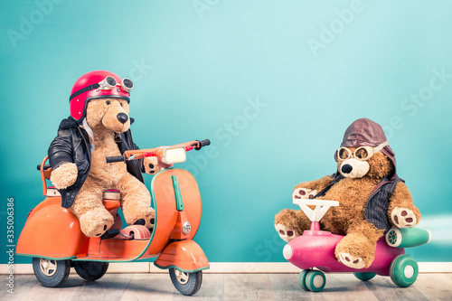 Photographie Retro Teddy Bear toy in helmet with goggles on old children's pedal scooter from 60s and Teddy Bear in leather aviator hat front mint blue background