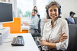 Portrait of smiling young woman operator in headset at office.