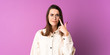 © luismolinero - Young woman over isolated purple background showing something