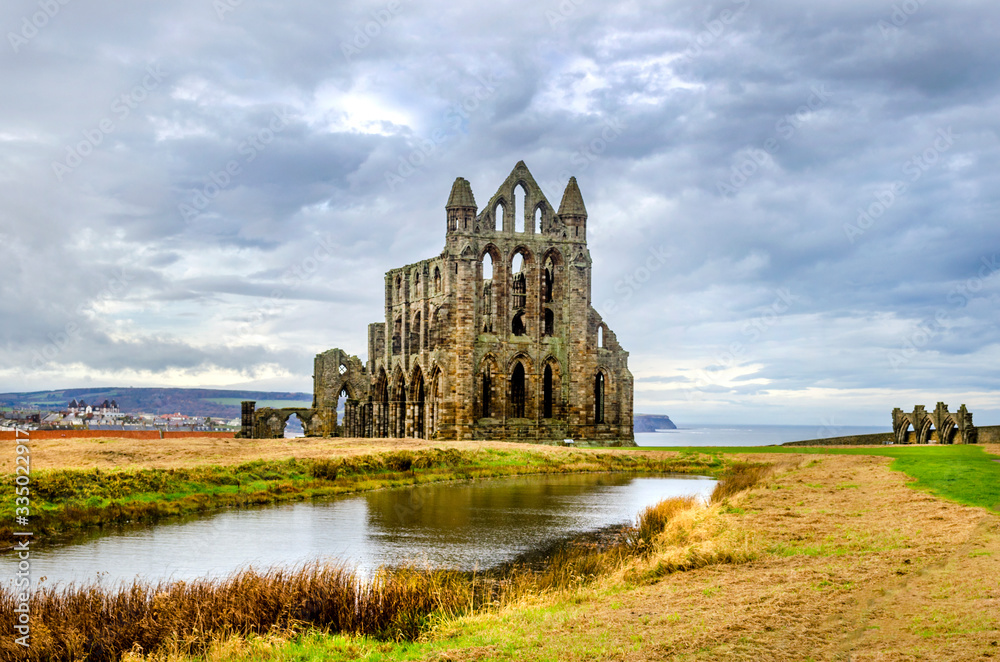 Whitby Abby now derelict and formally a Benedictine abbey and is situated overlooking the sea on the East cliff above the fishing village and is used today by sailors as a landmark at the headland. .  - obrazy, fototapety, plakaty 