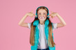 © Ilnur - A little girl with headphones explodes pink chewing gum on a pink background