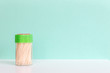 Bamboo or wooden toothpick in a plastic box on green background. Concept, Free space for text.