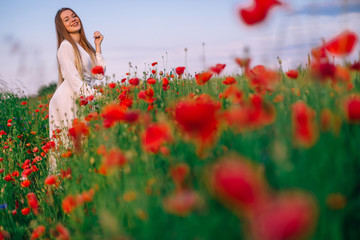 Wall Mural - beautiful red poppies in a field with tall grass. girl posing in