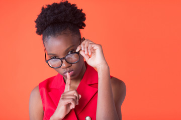 portrait of a beautiful young african woman on red background with hand gesture