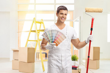 Sticker - House painter with a color swatch and a paint roller in a house