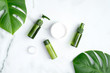 Set of natural organic cosmetics with green tropical leaves. SPA beauty products for skincare, body and hair care. Flat lay, top view, copy space