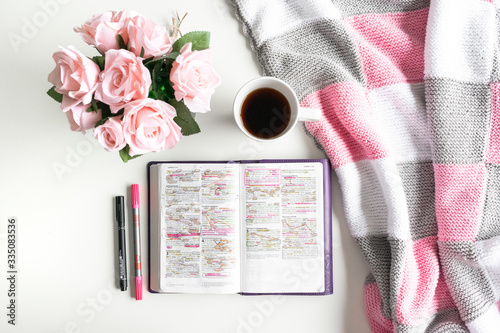 Pink Bible flat lay: Bouquet of pink roses, open Bible, black tea, coffee, journal, notebook, pen and pink blankets. Morning devotional. Rose, white, grey tones. Baselland, Switzerland - 02.04.2020