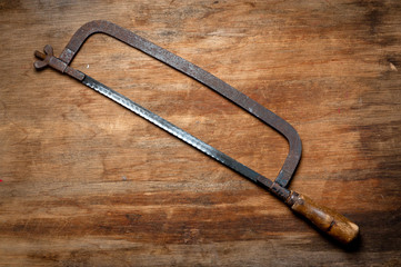 Old vintage metal hacksaw of the last century extracted from the chest in the workshop of grandfather. Background for craftsmanship and manual labor.