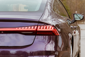 Premium LED sedan taillights. The car is purple in the street. close-up