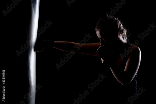 фотографія kick fighter girl punching a boxing bag