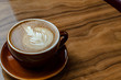 Latte cup of coffee side  on wooden table