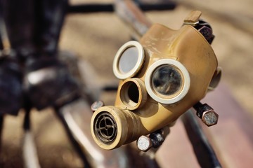 rubber gas mask close-up in a steel hand. the concept of the apocalypse, environmental disaster, nuc