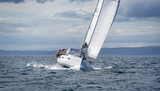 Fototapeta  - New sailing yacht going fast and beautiful directly on the camera. Sailing regatta in Scotland waters.